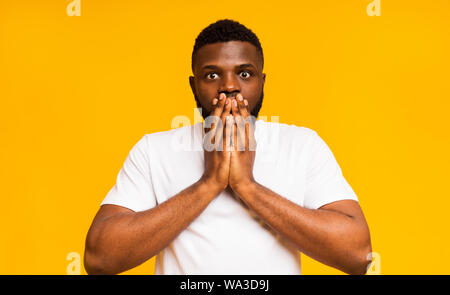 Shocked african guy shut his mouth in amazement Stock Photo