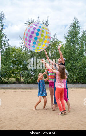 Odesa rgn. Ukraine, July 15, 2018: Children playing with a big colored ball, throwing it through the net in the summer camp. Stock Photo