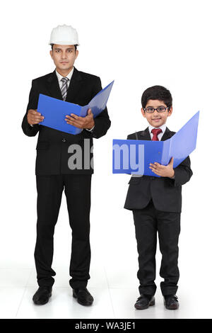 Boy imitating as a businessman and standing with his father Stock Photo