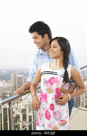 Young couple standing in a balcony Stock Photo