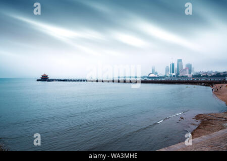 The trestle bridge by the sea, the Qingdao city landscape in the fog. Stock Photo