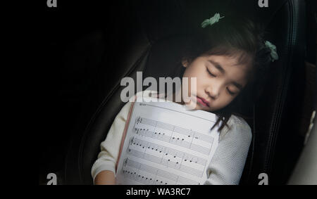 sleep kid with music note on seat car as love music concept. Kid spend time on auto Stock Photo