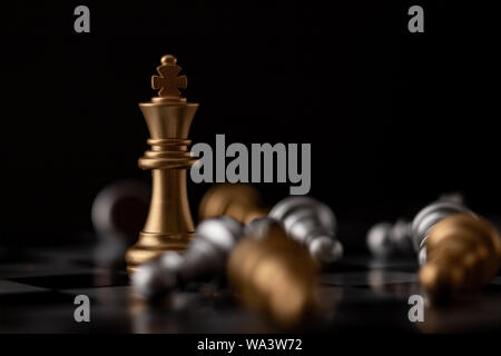 Gold king on board standing in the midst of falling chess Stock Photo