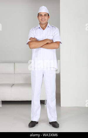 Peon standing with his arms crossed in office Stock Photo