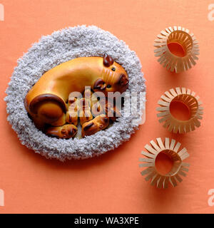 Close up of moon cake with mother pig and piglets shape in woolen basket near paper lanterns from top view, traditional pastry for mid autum season Stock Photo