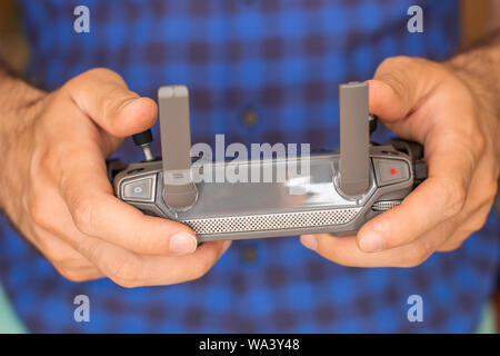 Hands with remote controller of drone outside. Man using RC for flying by drone Stock Photo
