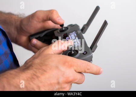 Hands with remote controller of drone outside. Man using RC for flying by drone Stock Photo