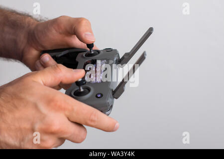 Hands with remote controller of drone outside. Man using RC for flying by drone Stock Photo