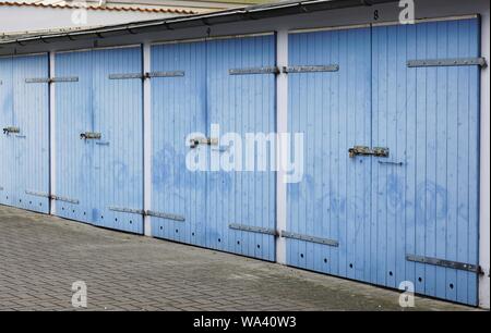 Closeup shot of garages in a row with blue wooden locked doors Stock Photo