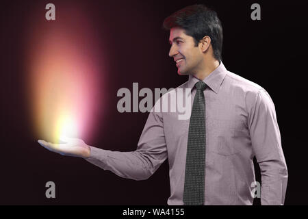 Businessman looking at lights coming from his palm Stock Photo