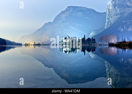 Toblino castle, manor of ancient legends, is reflected in the lake waters. Madruzzo, Trento province, Trentino Alto-Adige, Italy, Europe. Stock Photo