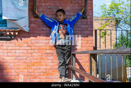 Kathmandu,  Nepal-November 03,2017: young serious looking asian boy is presenting proudly himself while playing in a temple Stock Photo