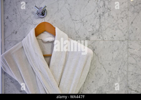 White Clean bathrobes hanging on wooden hanger Stock Photo