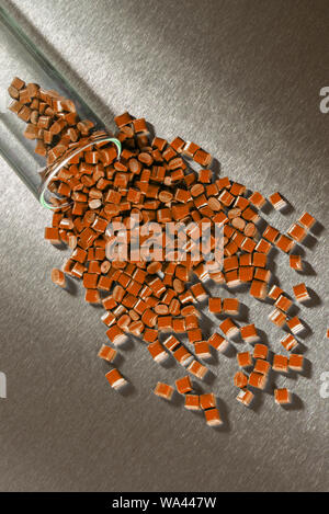 brown polymer granulat on stainless steel sheet in laboratory Stock Photo