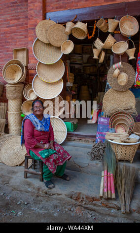 Kathmandu, Nepal-November 03,2017: smiling asian senior women in front of a household store selling wickerwork Stock Photo