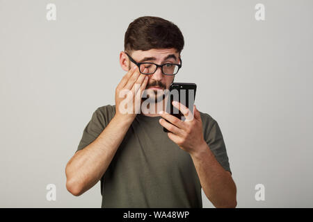 guy covers his face with his hand. Made a fatal mistake. He didn't choose what he needed. victim of stealing money online from hacker Stock Photo