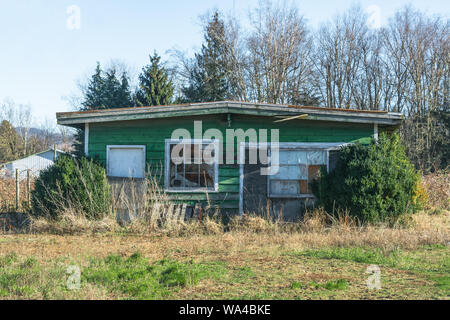 Old abandoned house in disrepair on cold fall day. Stock Photo