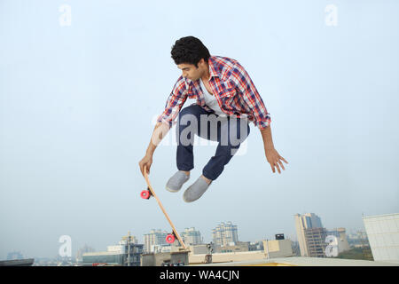 Young man performing jump on skateboard Stock Photo