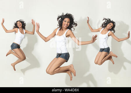 Multiple images of a young woman Listening to music and jumping Stock Photo