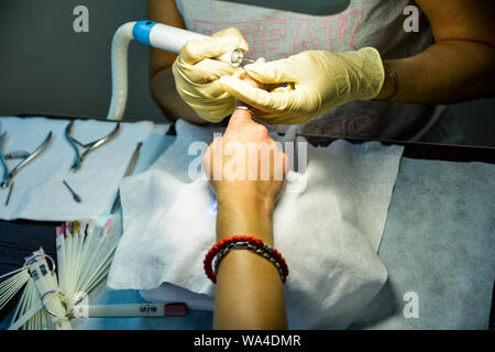 girl does a manicure procedure for applying varnish and polishing nails. Stock Photo