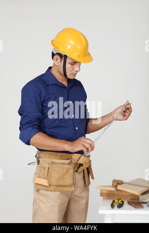 Carpenter with measuring tape Stock Photo