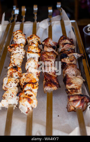 meat skewer. Skewers on skewers. Pork cooked on the fire. Ate the grill. Street freshly prepared food. Food on food parchment. Beautiful kebab. Nature Stock Photo