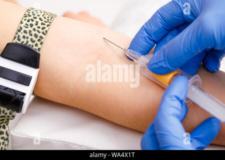 Close-up shot of doctor or nurse ready to take a blood sample from arm vein with a vacutainer. Venipuncture or venepuncture procedure Stock Photo