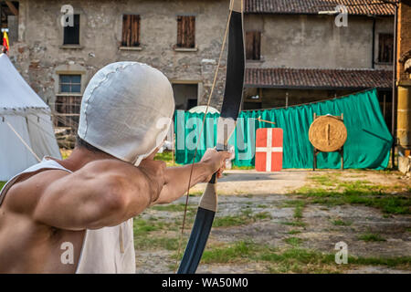 Archer shooting an arrow against the target Stock Photo