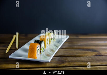 different rolls on a white rectangular plate on wooden background with copy space Stock Photo