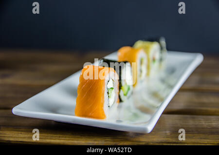different rolls on a white rectangular plate on wooden background Stock Photo