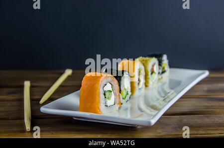 different rolls on a white rectangular plate on wooden background Stock Photo