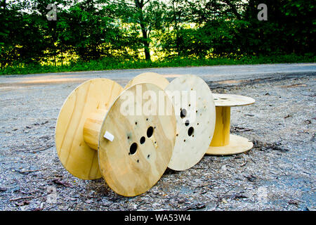 Old wooden cable bobbin discarded in countryside Stock Photo