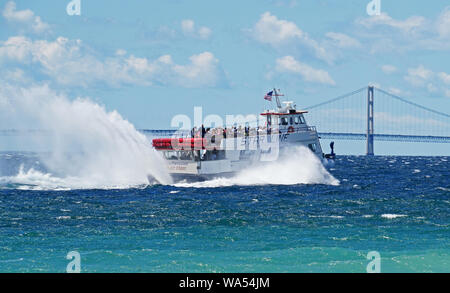 Star Line ferry from Mackinac Island crossing strait past the Mackinac Bridge to St. Ignace in Michigan's upper peninsula. Stock Photo