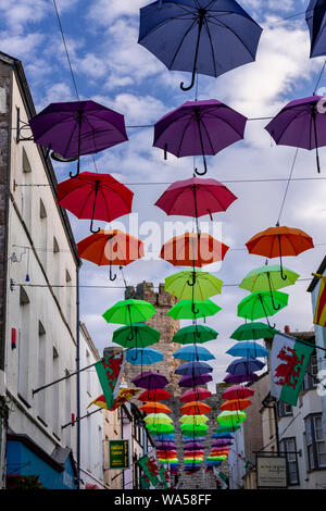 Multi-coloured umbrellas over Palace Street, Caernarfon, North Wales Stock Photo