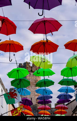 Multi-coloured umbrellas over Palace Street, Caernarfon, North Wales Stock Photo