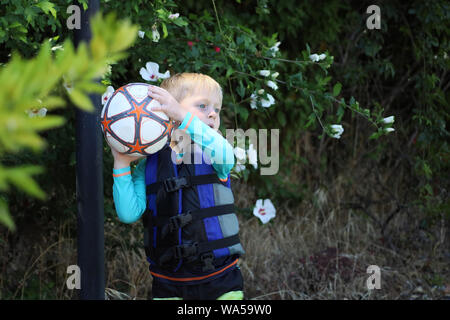 Little boy learning the throw in for soccer. Stock Photo