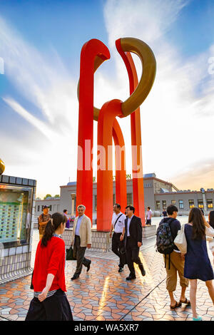 Ueno, Japan - 15 June 2015 - People walk on pedestrian deck near an orange sculpture outside of Ueno station on June 15, 2015 in Ueno, Japan Stock Photo