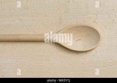 wooden spoon on wooden cutting board closeup