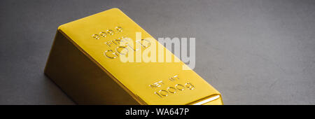 Gold bar ingot bullion on a gray background. Located diagonally Stock Photo
