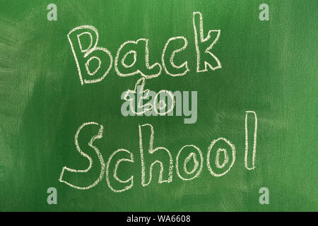 Back to school concept with written words in chalk on green blackboard. The beginning of the school year. Lettering Stock Photo