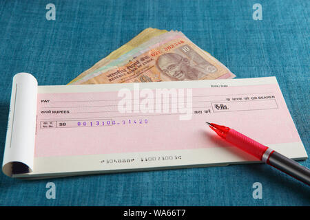 Indian rupees with a cheque book Stock Photo