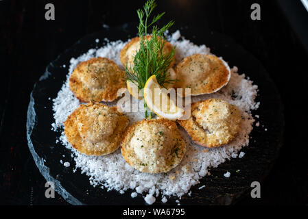 deep fried Hokkaido Scallops Shell with crusty bread serve with lemon and salt. Stock Photo