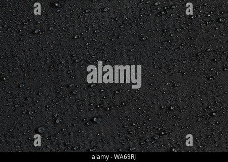 dark gray waterproof hydrophobic flat cloth closeup with rain drops background Stock Photo