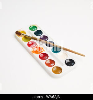 Watercolor paint in white box and brush isolated on white background Stock Photo