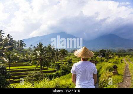 Man with traditional balinese cap at rice fields of Jatiluwih in southeast Bali, Indonesia Stock Photo
