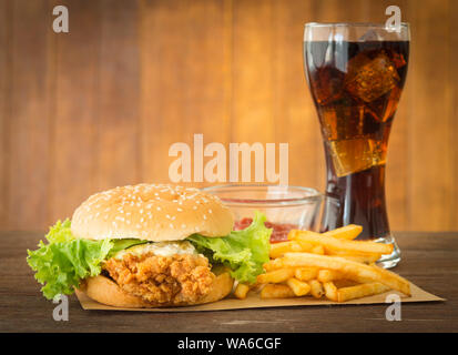 fast food set hamburger and french fries with cola on wood background. Stock Photo