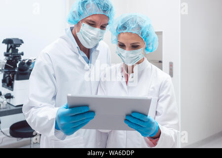 Two scientists working together in lab looking at data Stock Photo