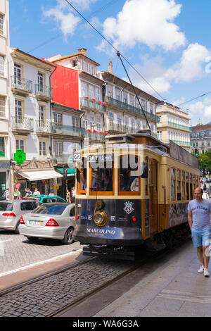 Portugal Oporto Porto Rua dos Clérigos street scene old tram streetcar rails lines cars traffic sidewalk pavement houses balconies shops stores Stock Photo