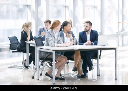 Business team sitting by the table with laptop and documents in office Stock Photo