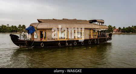 ALLEPPEY, INDIA, MAR 13, 2018: Bamboo thatched houseboat floats down the backwaters of Kerala Stock Photo